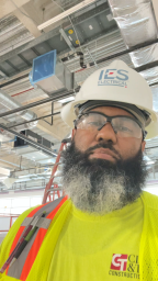 Aaron in yellow safety gear and white hardhat
