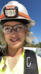 Hannah in white hardhat smiling into camera