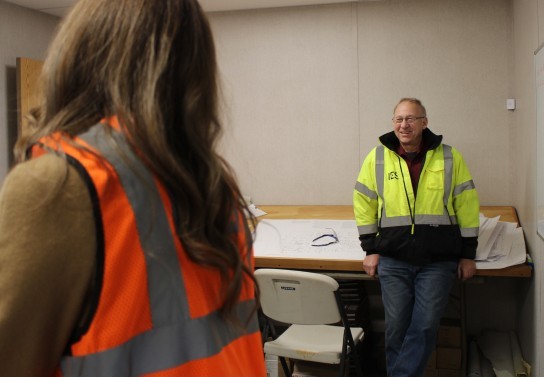 IES employee in safety yellow jacket smiling at coworker