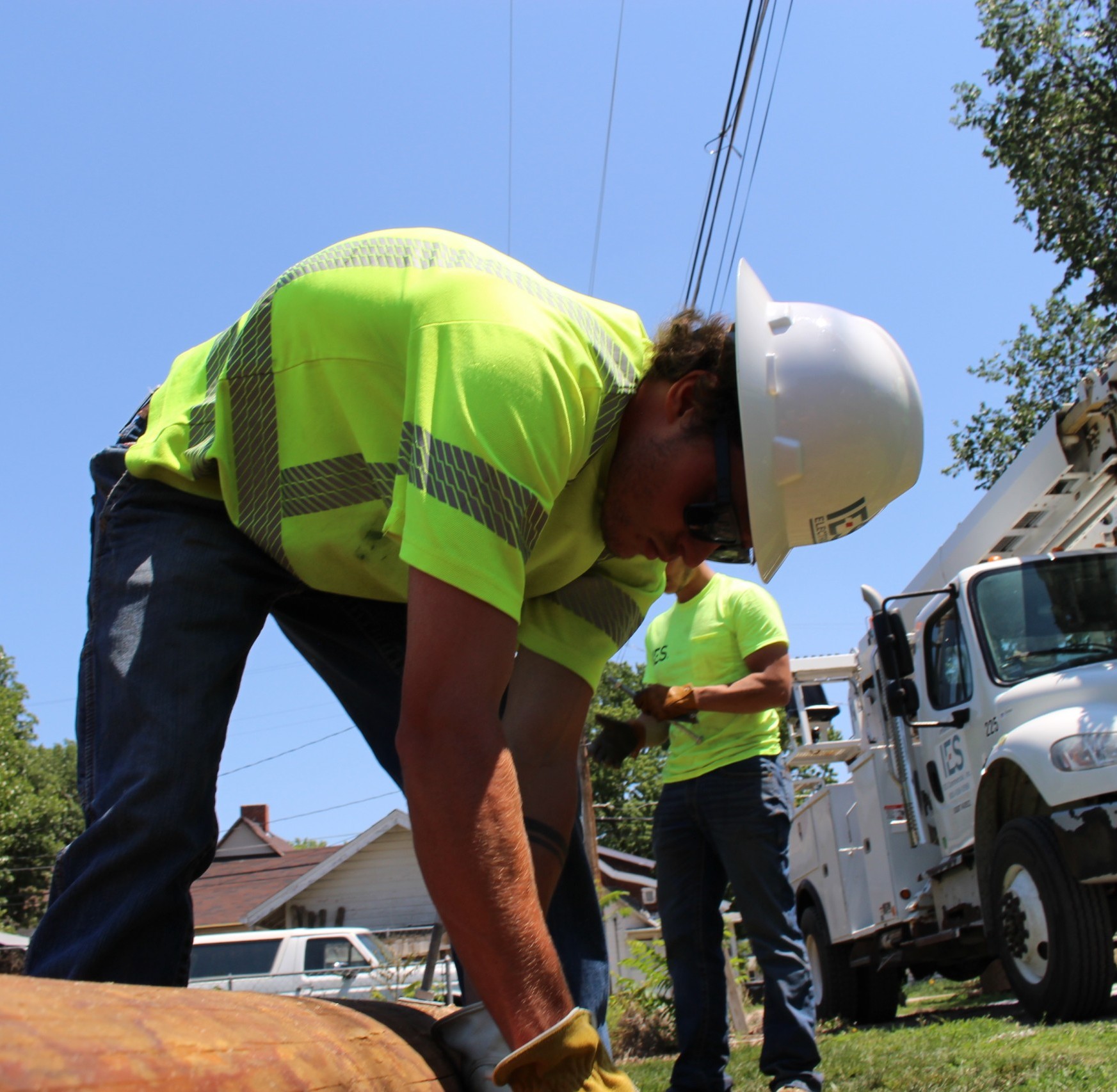 IES employee under electrical line fixing metal piping