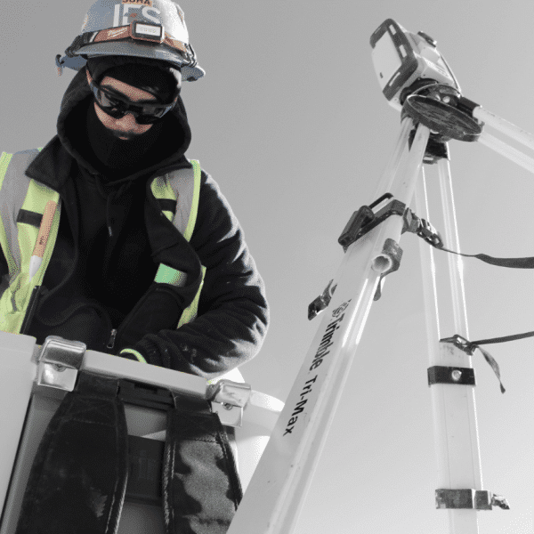 Black and white image of IES employee in full color working at tripod