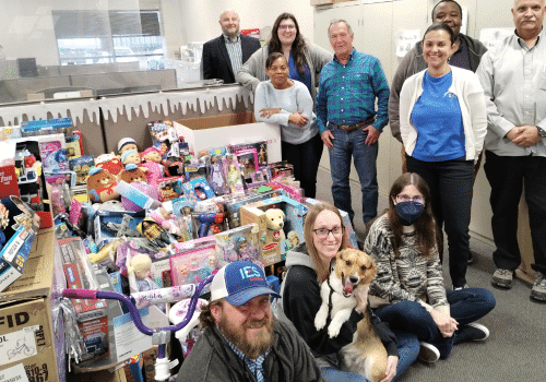 Three IES employees standing in front of toy donation