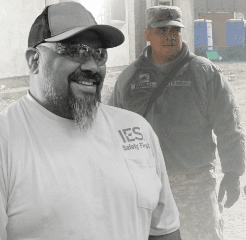 Black and white portrait of IES employee superimposed over full color image of same employee in full military uniform with gear