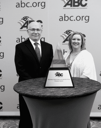 Black and white image of man and woman behind pyramid ABC award