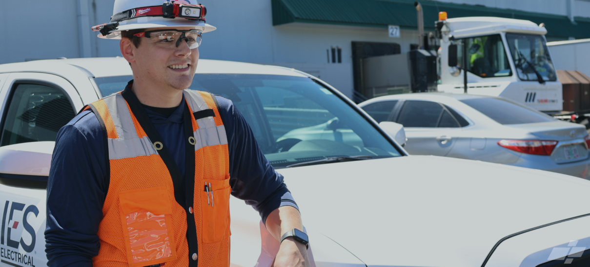 Cameron wearing orange safety vest and white hardhat