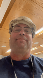 Portrait of Dean in glasses wearing a hardhat
