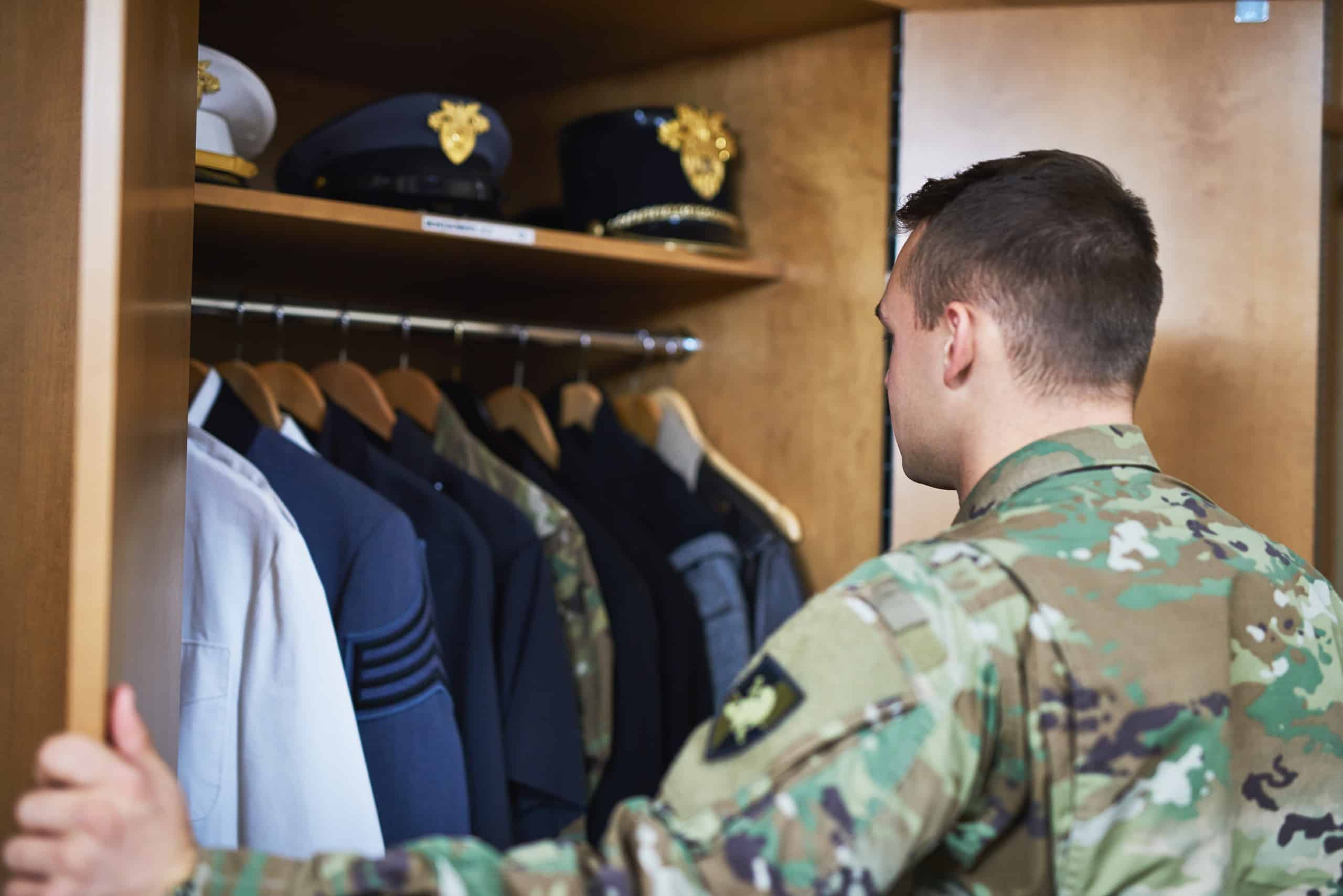 Shot of a young soldier standing getting dressed in the dorms of a military academy.
